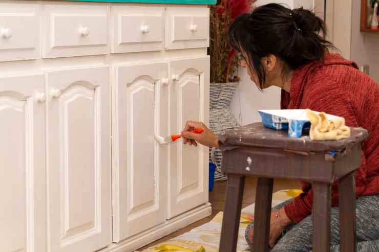 Donna dipinge i mobili di bianco