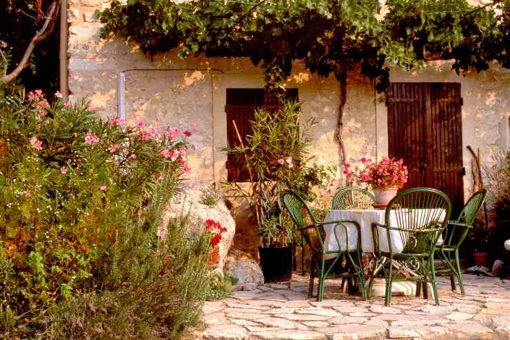 Giardino rustico arredato con zona pranzo e piante 