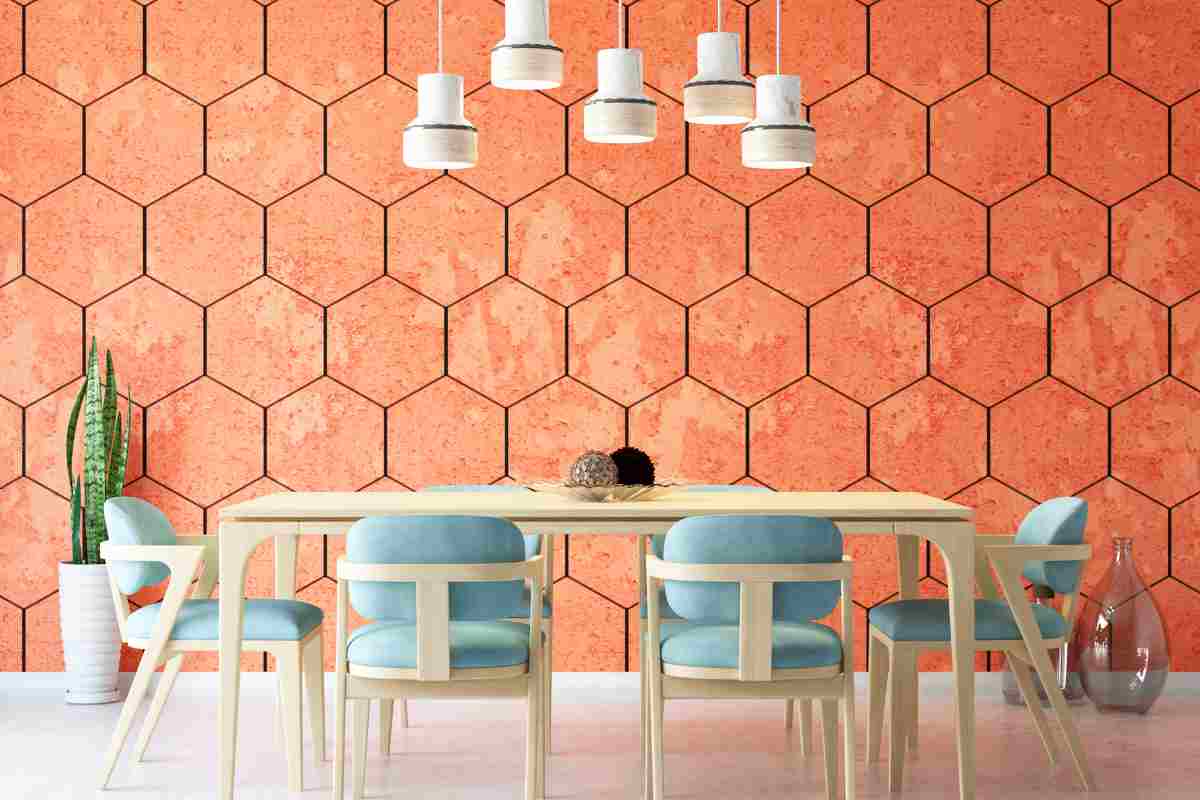 parete in tonalità mattone con elementi esagonali, il tavolo è un legno chiaro e le poltrone attorno al tavolo hanno imbottitura celeste