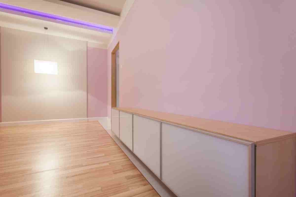 stanza con arredo minimal e pareti rosa