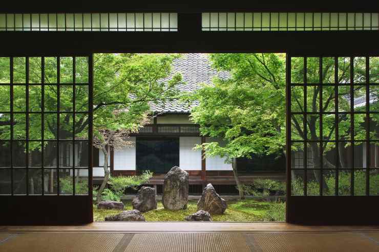 Giardino zen che si intravede dall'interno con porte finestre scorrevoli