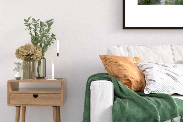 candele su comodino in un soggiorno con coperta verde