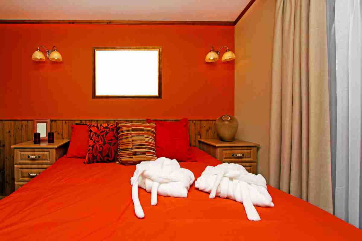 camera da letto con mobili ciliegio e parete rossa