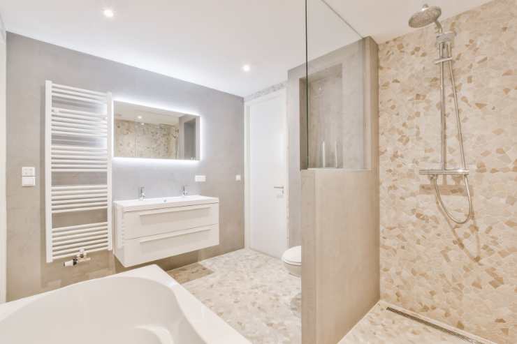 Rivestimenti bagno moderno piastrelle in zona doccia e carta parati in zona lavabo
