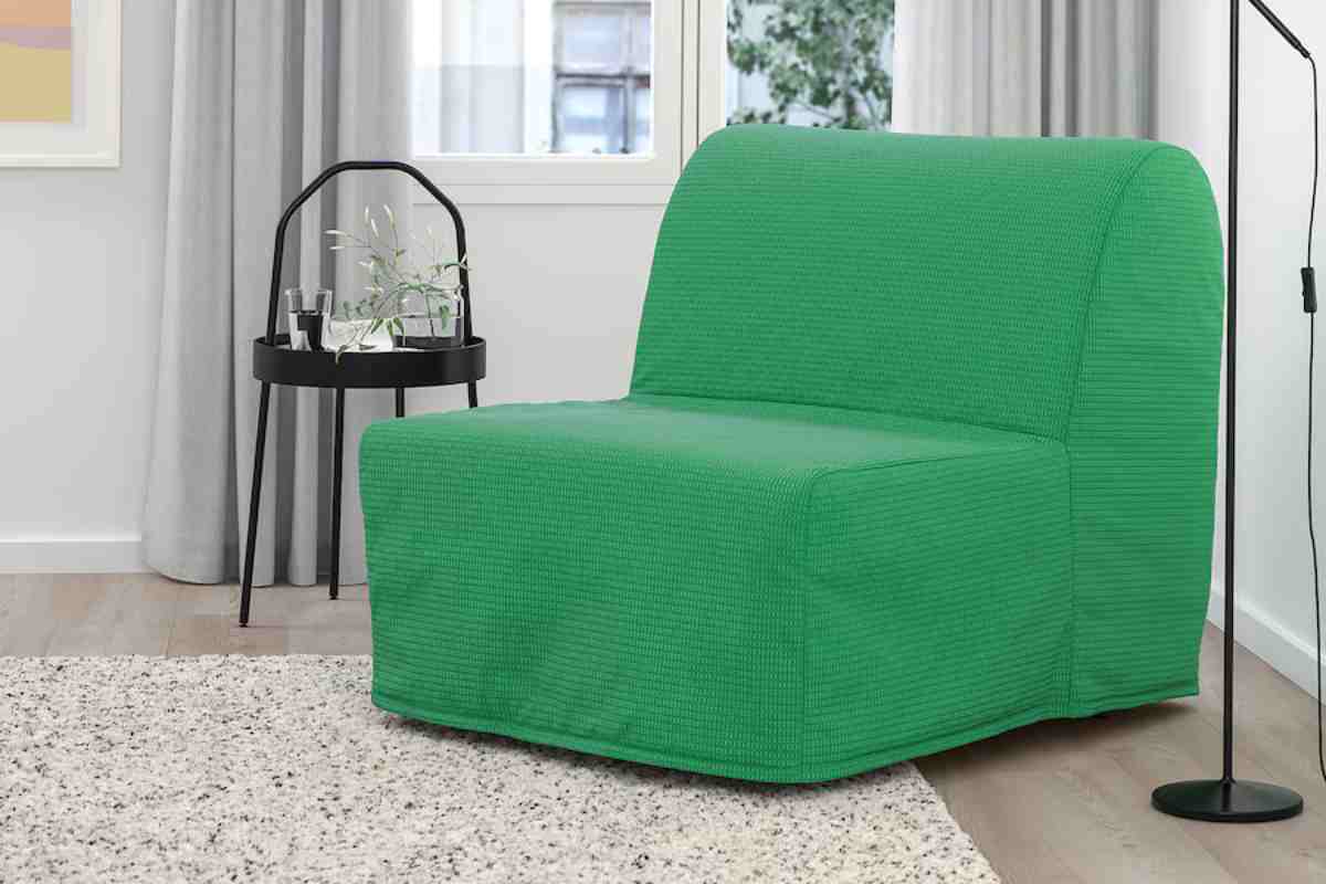 Poltrone letto Ikea qui modello LYCKSELE verde in un angolo con lampada e tavolino