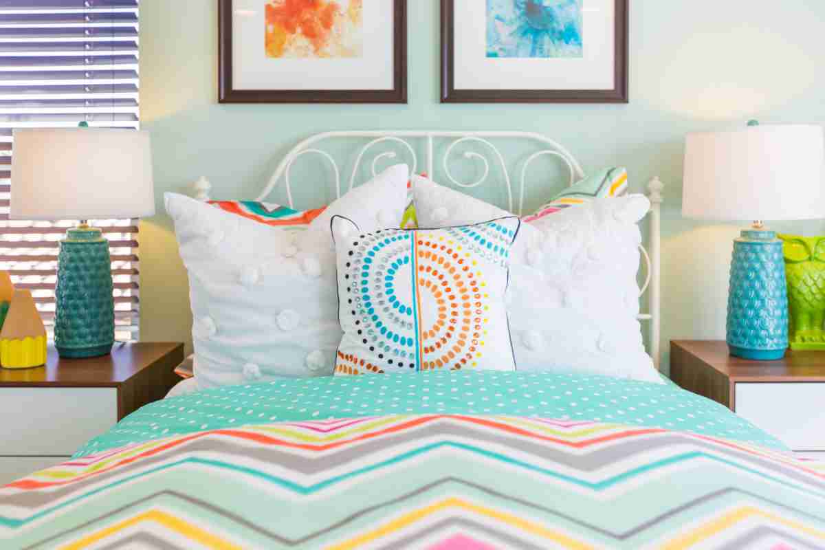 Camera da letto moderna rettangolare arredata con complementi di arredo colorati