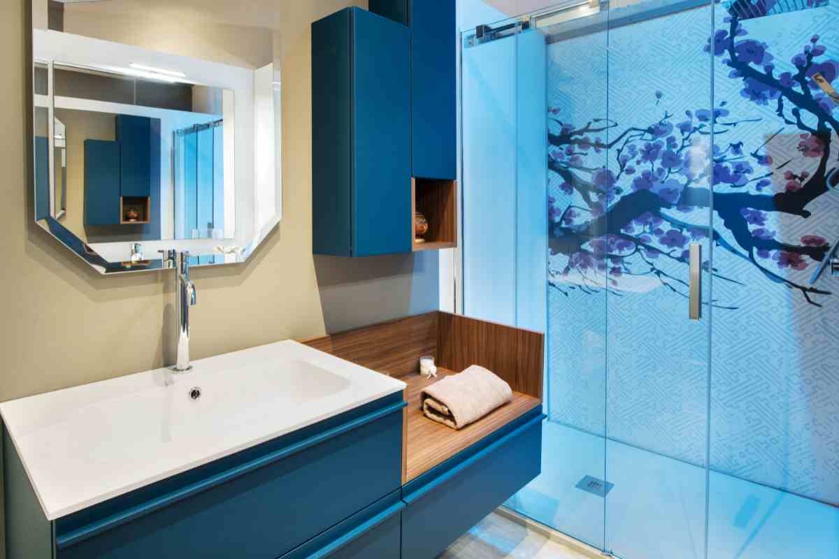 bagno arredato con il colore blu e disegno su parete doccia blu