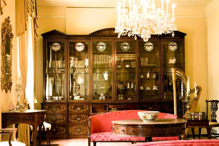 interno di un soggiorno con tappeti, tende e specchi arredato in stile vittoriano
