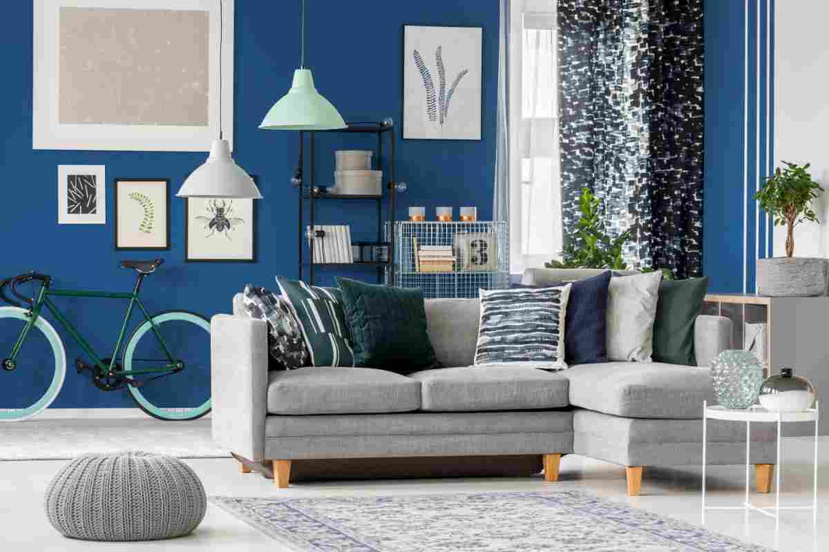 soggiorno con pareti blu e divano grigio