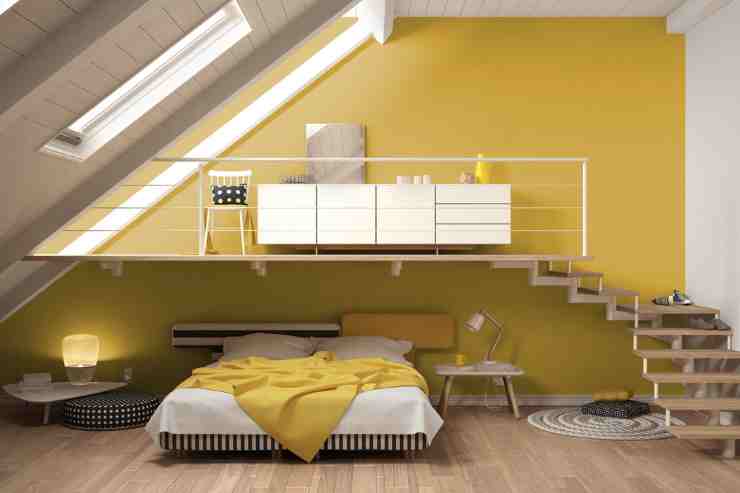 Camera da letto stile loft con pareti colorate di giallo