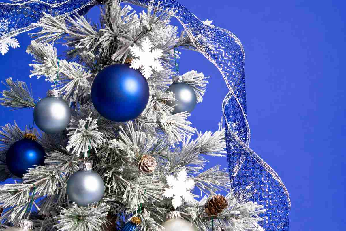 zoom su ramo di un albero di natale di colore argento con pallina di colore blu