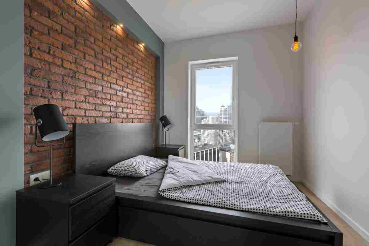 Camera da letto in stile industriale con lampade alle pareti
