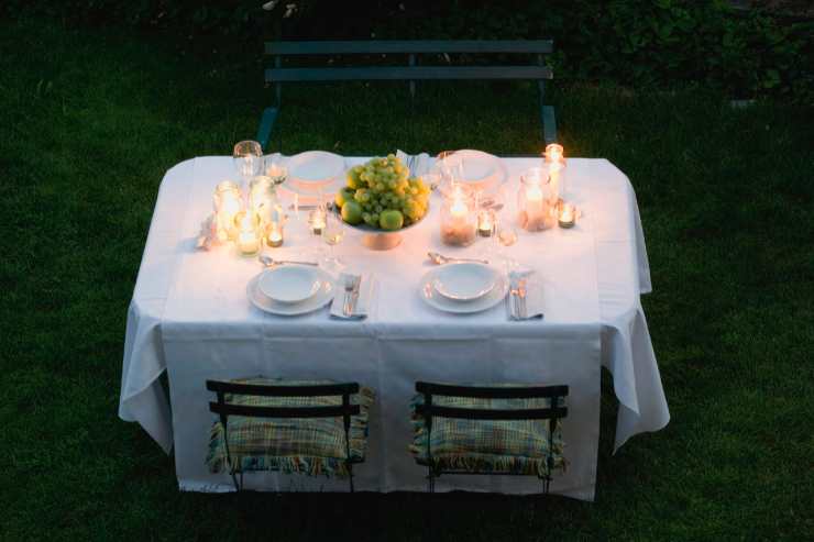 Tavolo in giardino apparecchiato per la cena 