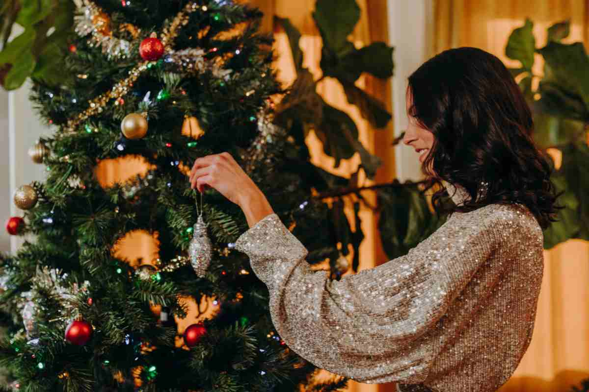 donna addobba l'albero di Natale