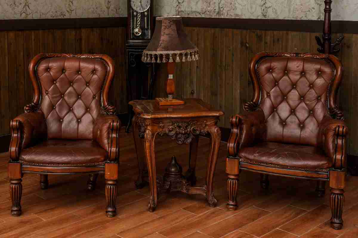 poltrone e tavolino in legno di noce in soggiorno con boiserie in stile classico