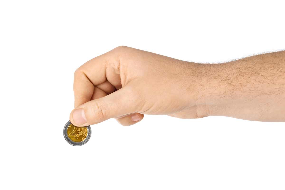 moneta tra le dita di una mano