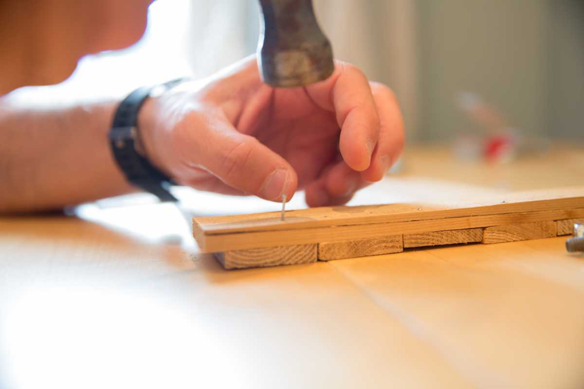 mani di un uomo che lavorano sul legno