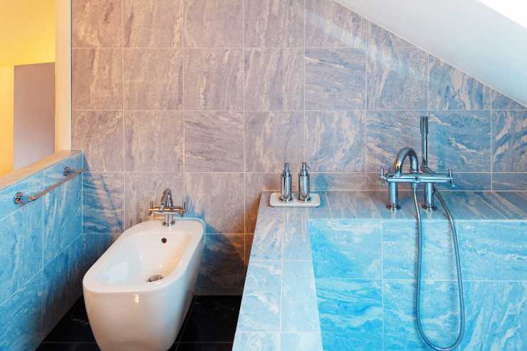 Bagno con piastrelle blu e vasca