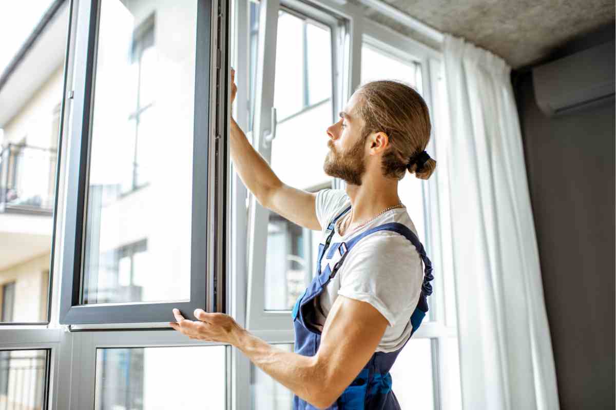 uomo cambia finestra per i lavori in casa da fare prima che arrivi l'autunno