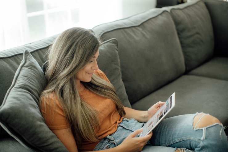 donna legge su un tablet seduta sul divano