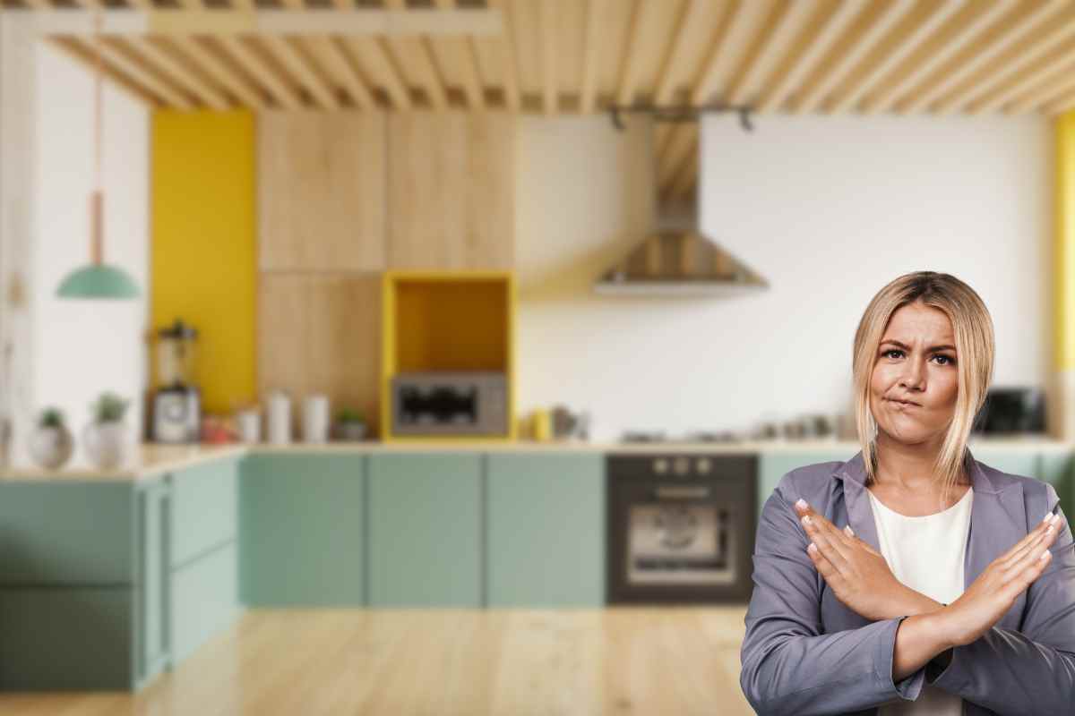 cucina verde e gialla su sfondo donna con braccia incrociate