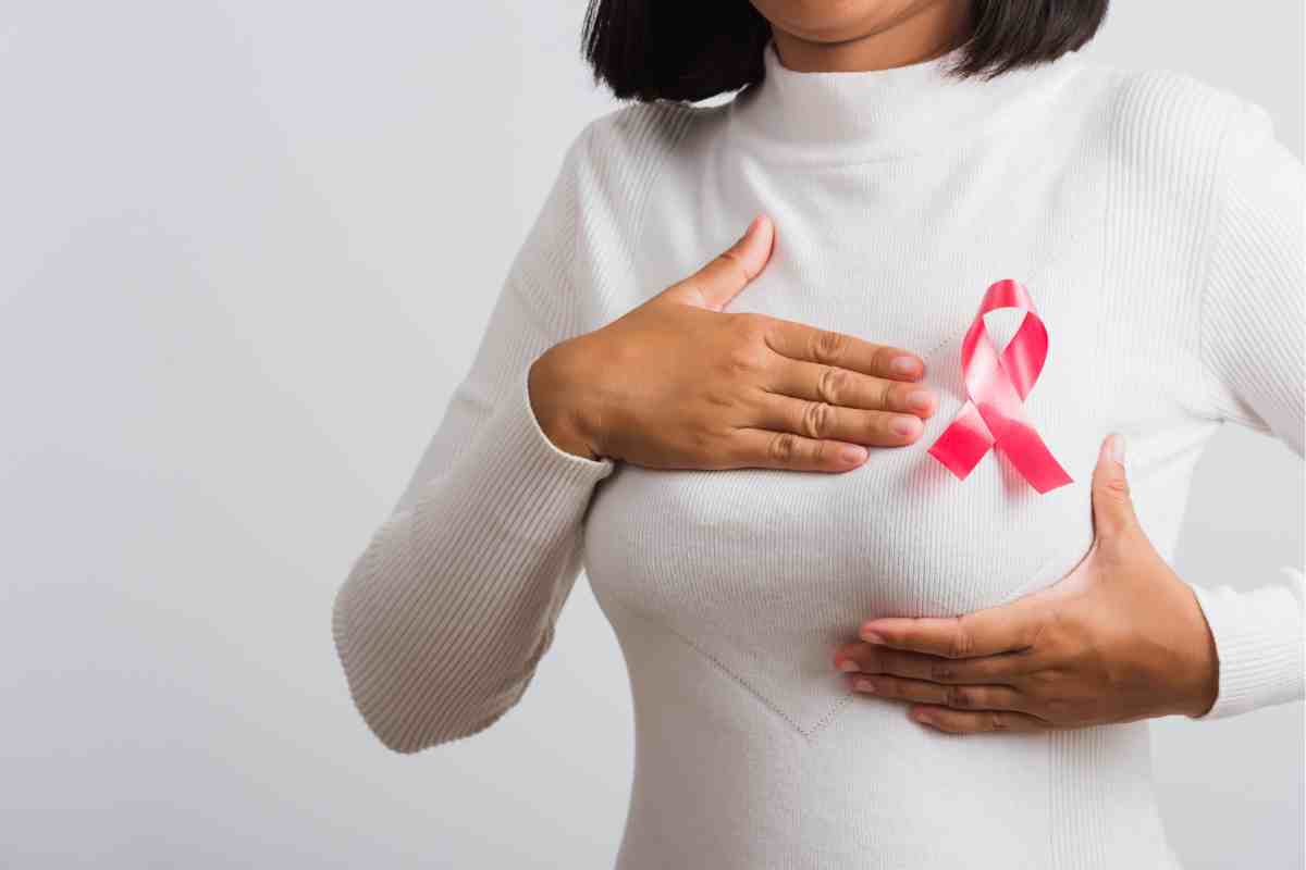 donna con una coccarda sul seno per il mese di prevenzione ottobre rosa 