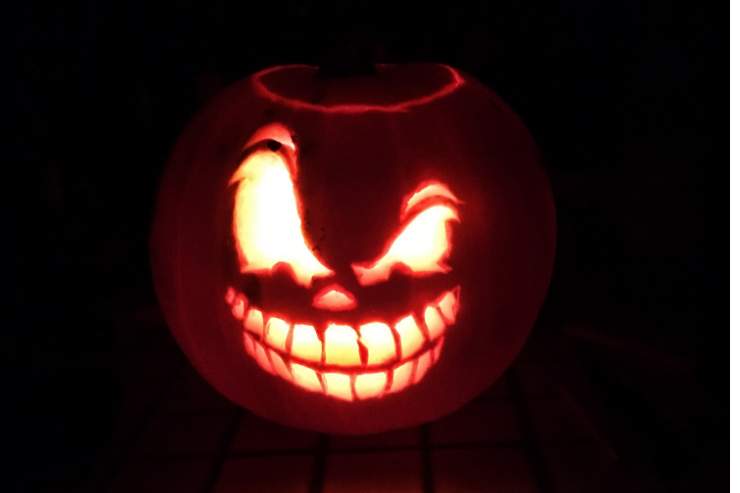 Zucca di Halloween intagliata e illuminata da dentro in una stanza buia