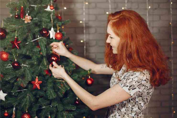 donna mostra come addobbare l'albero di Natale 