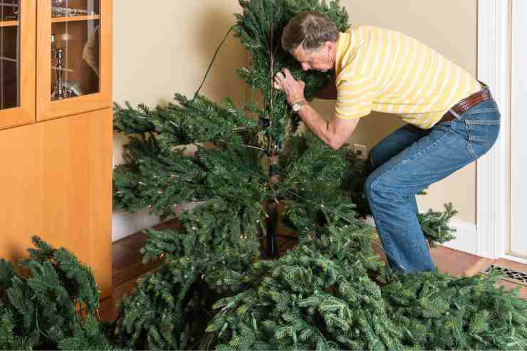 uomo intento a montare l'albero di natale artificiale