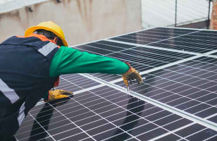 Tecnico che installa pannelli fotovoltaici