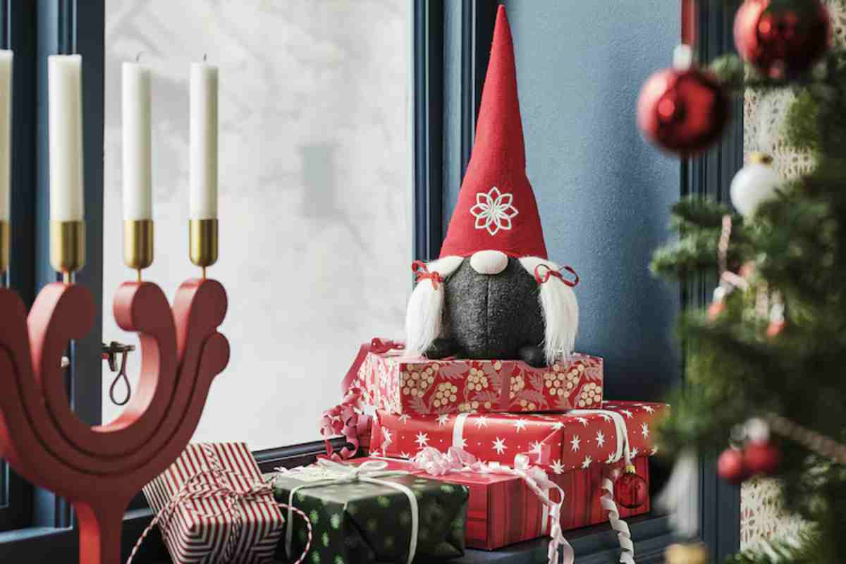 Uno degli gnomi natalizi Ikea vicino all'albero di Natale