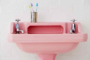 Un esempio di lavandini colorati in bagno, qui modello rosa con rubinetti cromati