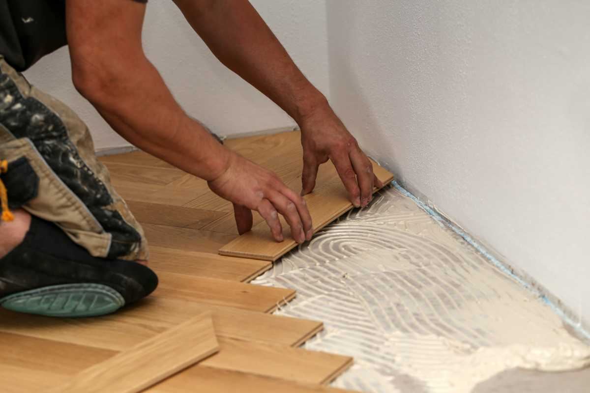 Operaio installa pavimento in legno