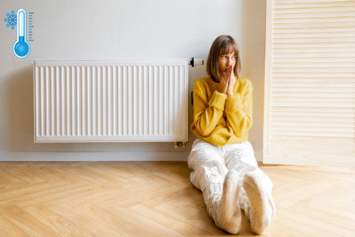 ragazza seduta vicino termosifone simbolo freddo