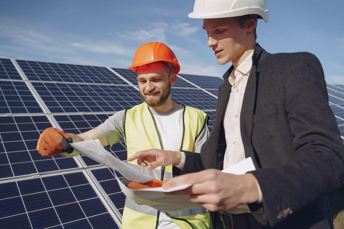 Tecnici fotovoltaici che guardano dei documenti