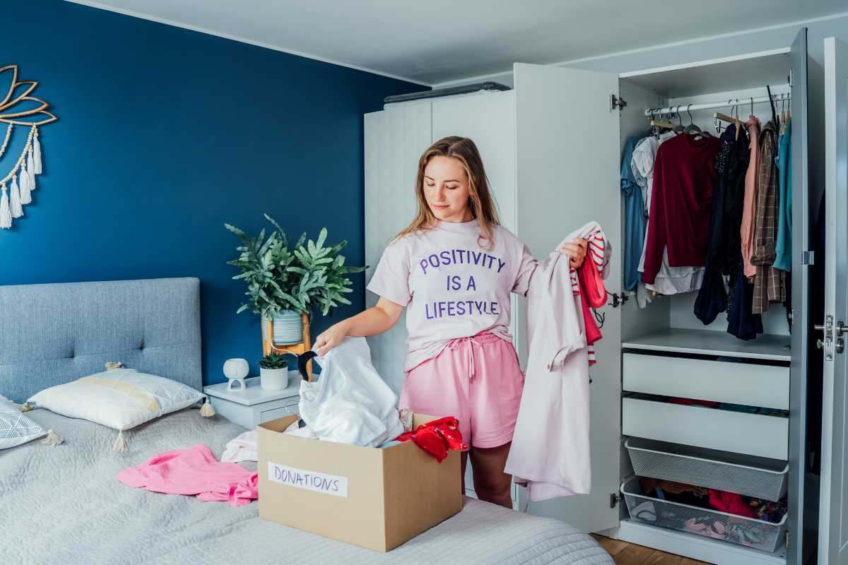 Ragazza sistema abiti in una scatola