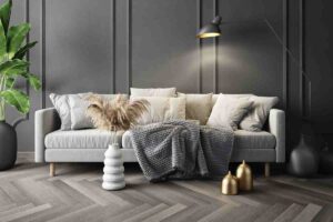 soggiorno con parquet grigio e divano colori neutri con lampada illuminata