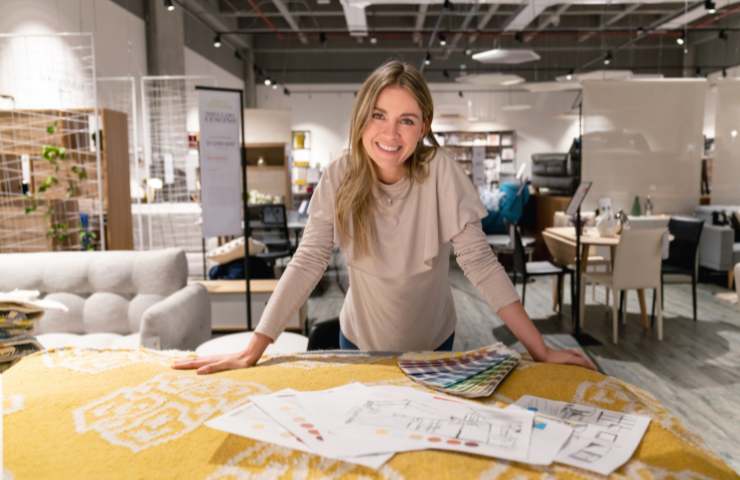 ragazza appoggiata a tavolo di lavoro con progetti 